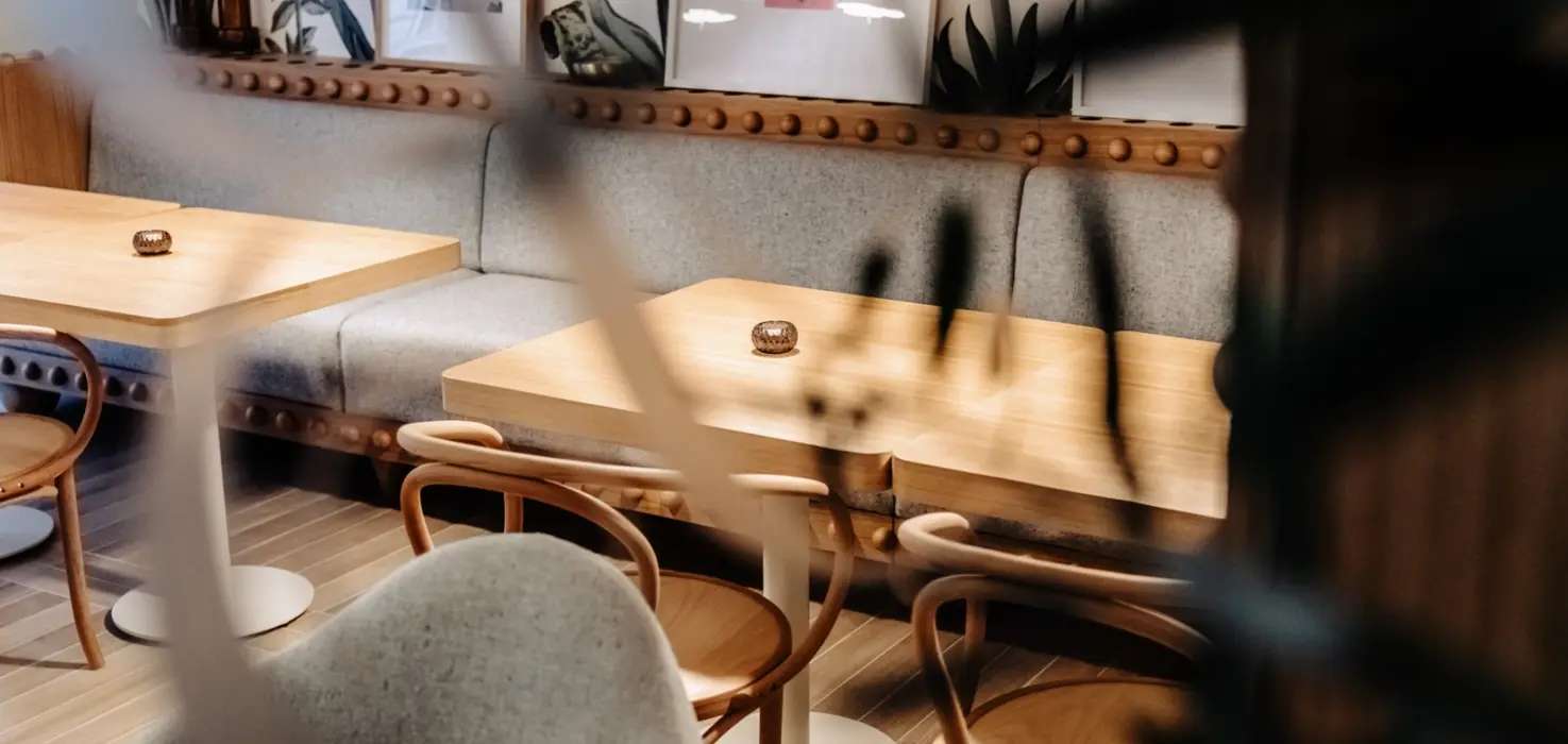 Jasna sala Belli, dębowe stoliki i krzesła thonet przy szarej kanapie